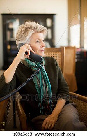 Stock Image - Senior woman on landline phone. Fotosearch