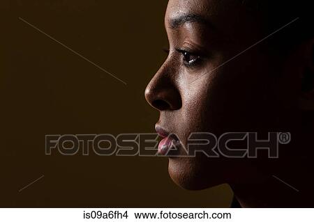 Side view of young woman on black background View Large Photo Image Picture - Side view of young woman on black background. Fotosearch