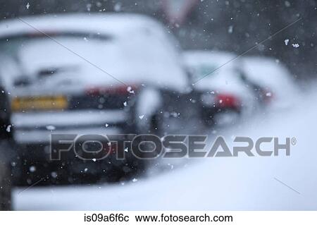 Stock Image - Snow flakes and row of cars. Fotosearch