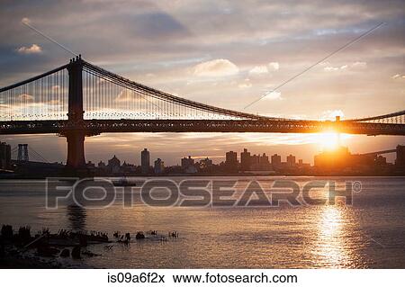 Sunset behind Manhattan bridge, New York City, USA View Large Photo Image Stock Photo - Sunset behind Manhattan bridge, New York City, USA. Fotosearch