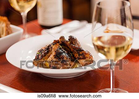 Stock Photo - Table set with chicken dish and white wine. Fotosearch