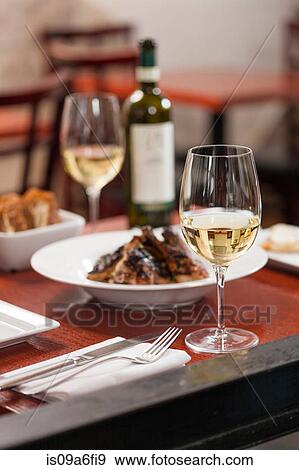 Table set with dish and white wine View Large Photo Image Stock Photo - Table set with dish and white wine. Fotosearch