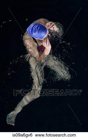 Stock Photograph - Teenage girl adjusting goggles in swimming pool. Fotosearch