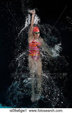 Stock Image - Teenage girl doing backstroke in swimming pool. Fotosearch
