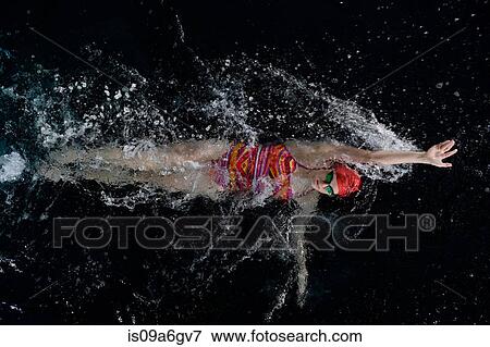 Stock Photo - Teenage girl doing backstroke in swimming pool. Fotosearch