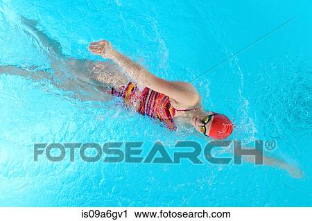 Stock Image - Teenage girl doing front crawl in swimming pool. Fotosearch