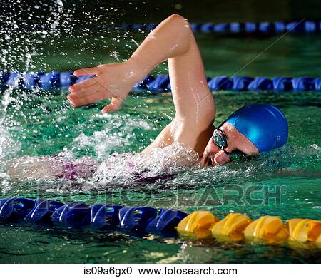Stock Image - Teenage girl doing front crawl in swimming pool. Fotosearch