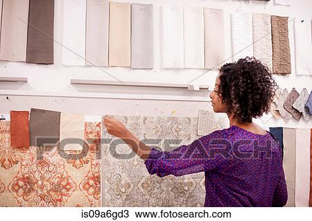 Stock Image - Textile designer with fabric swatches. Fotosearch