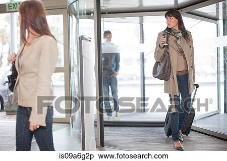 Stock Photography - Three people arriving at airport terminal. Fotosearch
