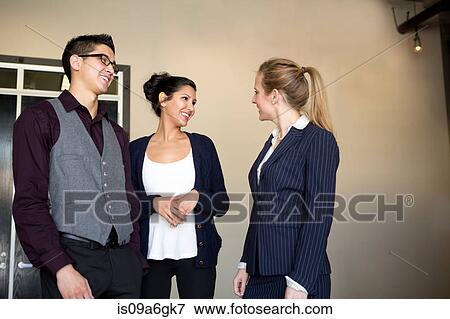 Stock Photo - Three young businesspeople talking. Fotosearch