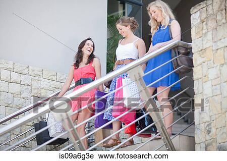 Stock Image - Three young women with shopping bags. Fotosearch