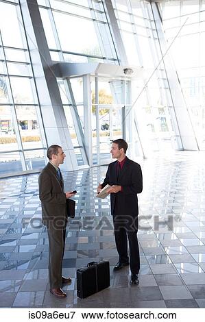 Stock Photo - Two businessmen in lobby with briefcase. Fotosearch