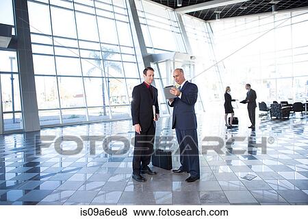 Stock Photo - Two businessmen using digital tablet. Fotosearch
