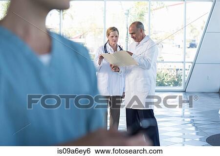 Two doctors discussing medical records View Large Photo Image Stock Photograph - Two doctors discussing medical records. Fotosearch