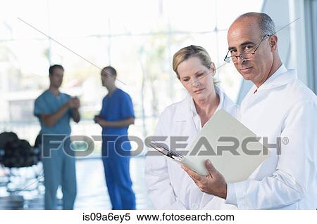 Stock Photography - Two doctors discussing medical records. Fotosearch
