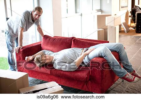 Two removals men, one lying on sofa View Large Photo Image Stock Photograph - Two removals men, one lying on sofa. Fotosearch