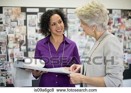 Two textile designers discussing notebook View Large Photo Image Stock Photo - Two textile designers discussing notebook. Fotosearch