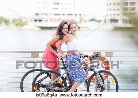 Stock Image - Two young women on a bicycle. Fotosearch
