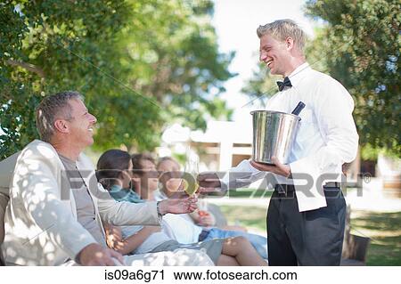 Waiter serving customers in garden View Large Photo Image Stock Image - Waiter serving customers in garden. Fotosearch