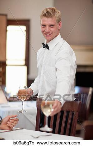 Waiter serving white wine in restaurant View Large Photo Image Stock Image - Waiter serving white wine in restaurant. Fotosearch
