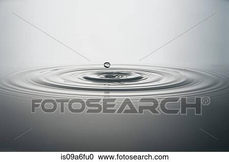 Stock Image - Water droplet falling into water. Fotosearch