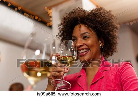 Stock Photography - Woman raising wine glass to drink. Fotosearch