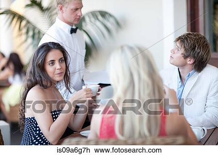 Young adults in restaurant with waiter View Large Photo Image Stock Image - Young adults in restaurant with waiter. Fotosearch