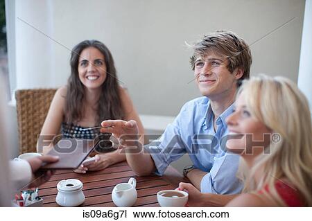 Stock Image - Young adults ordering in cafe. Fotosearch