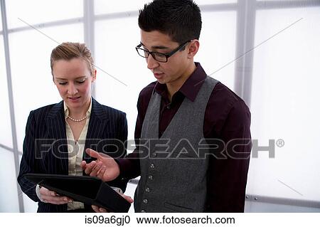 Stock Image - Young businesspeople using digital tablet. Fotosearch