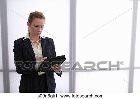 Stock Image - Young businesswoman using digital tablet. Fotosearch