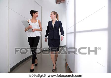 Young businesswomen walking in corridor View Large Photo Image Stock Photograph - Young businesswomen walking in corridor. Fotosearch
