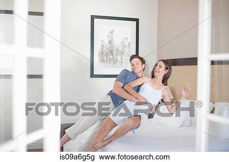 Young couple falling on bed View Large Photo Image Stock Image - Young couple falling on bed. Fotosearch