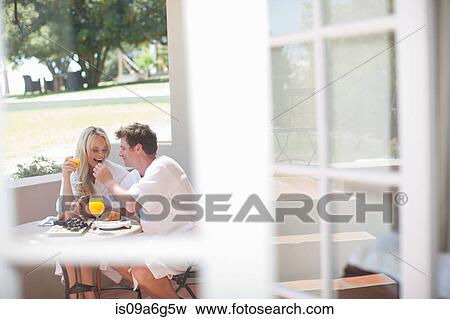 Young couple having breakfast on patio View Large Photo Image Stock Photo - Young couple having breakfast on patio. Fotosearch