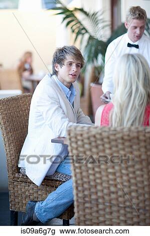 Young couple in restaurant with waiter View Large Photo Image Stock Image - Young couple in restaurant with waiter. Fotosearch