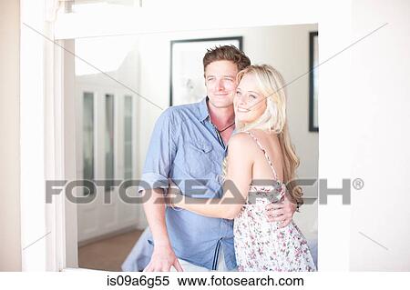 Stock Photography - Young couple looking through window. Fotosearch
