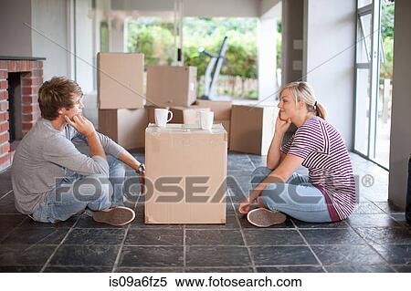 Young couple moving house sitting on floor with box View Large Photo Image Stock Photography - Young couple moving house sitting on floor with box. Fotosearch