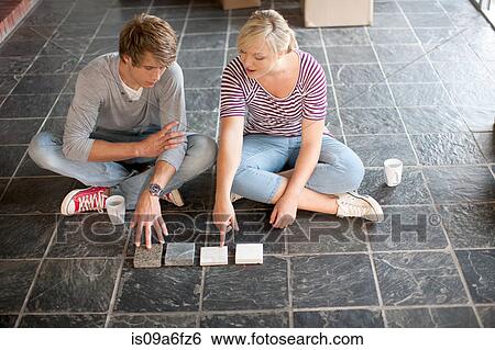 Young couple sitting on floor choosing new tiles View Large Photo Image Stock Photograph - Young couple sitting on floor choosing new tiles. Fotosearch