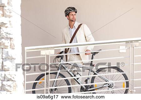 Young man by railing with bicycle View Large Photo Image Stock Photo - Young man by railing with bicycle. Fotosearch