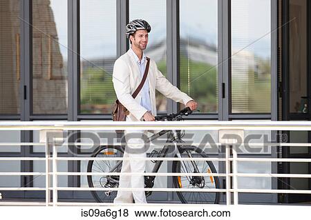 Young man by railing with bicycle View Large Photo Image Stock Photo - Young man by railing with bicycle. Fotosearch