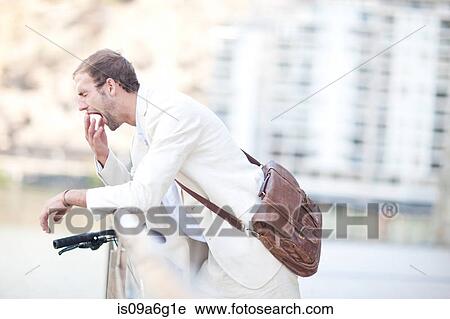 Young man by railings yawning View Large Photo Image Stock Image - Young man by railings yawning. Fotosearch