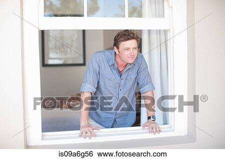 Young man looking through window View Large Photo Image Stock Photograph - Young man looking through window. Fotosearch