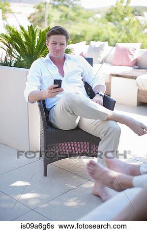Stock Photograph - Young man texting on smartphone. Fotosearch