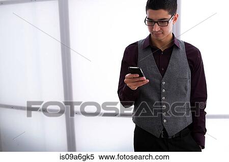 Stock Photography - Young man texting on smartphone. Fotosearch