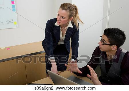 Young man using laptop with female manager View Large Photo Image Stock Image - Young man using laptop with female manager. Fotosearch