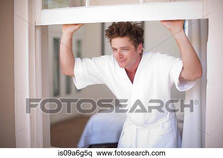 Young man wearing bathrobe by window View Large Photo Image Stock Photography - Young man wearing bathrobe by window. Fotosearch