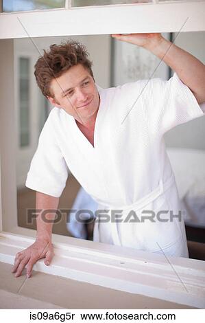 Young man wearing bathrobe by window View Large Photo Image Stock Photography - Young man wearing bathrobe by window. Fotosearch