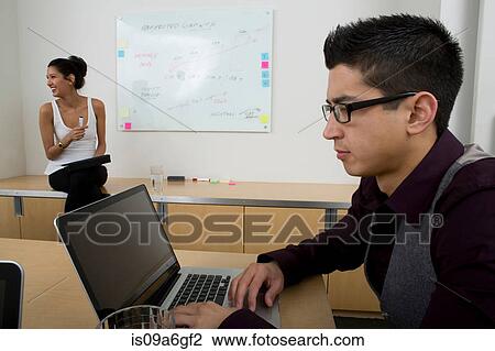 Young man wearing glasses using laptop View Large Photo Image Stock Image - Young man wearing glasses using laptop. Fotosearch