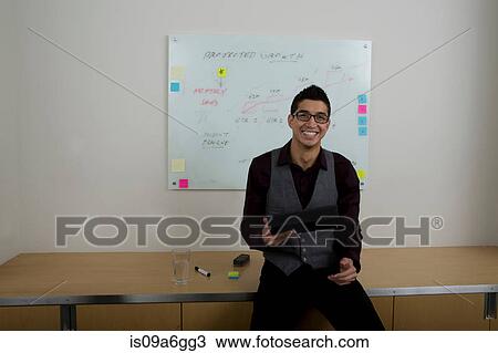 Stock Image - Young man with whiteboard in background. Fotosearch