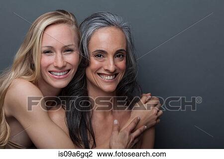 Stock Image - Young woman and mature woman hugging. Fotosearch