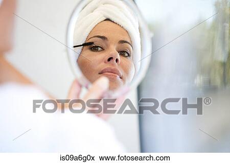 Stock Photo - Young woman applying mascara. Fotosearch